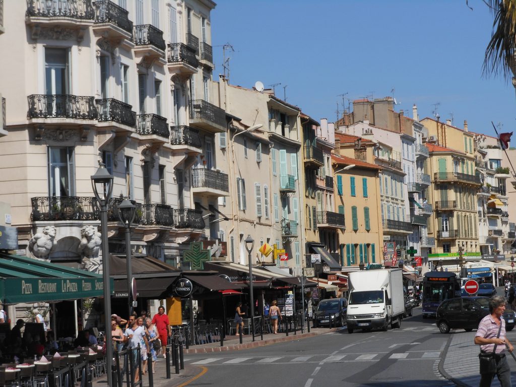Străzile din Cannes, cu terase, clădiri mediteraneene și atmosfera animată a Rivierei Franceze.